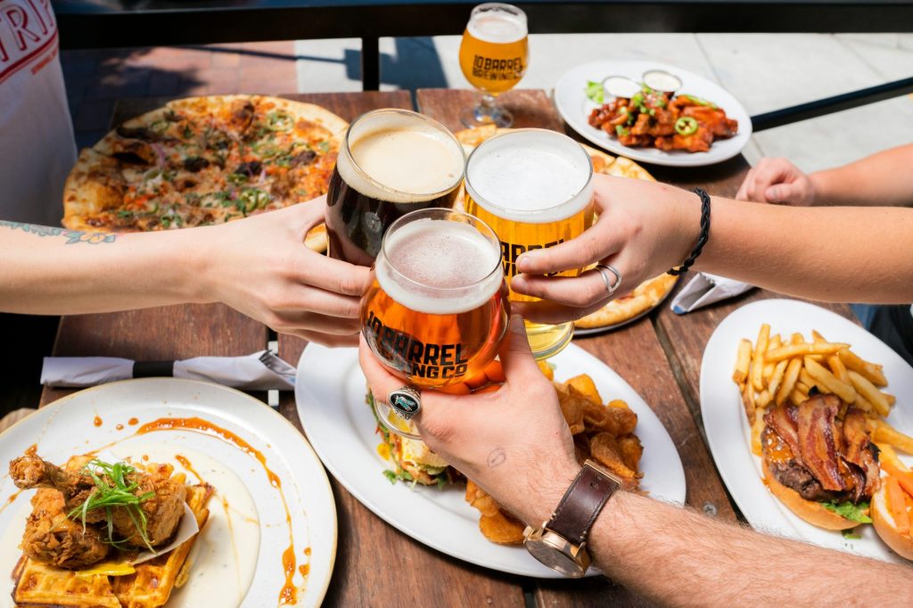 Friends toasting with beers and food